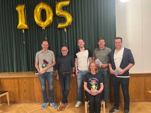 Gruppenfoto von Mitgliedern des TuS Horn mit Urkunden und Blumen in den Händen.