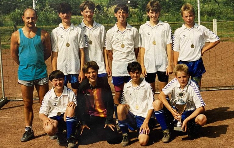 Gruppenfoto Jugend-Fußballmannschaft des TuS Horn mit Trainer. Alle tragen Medaillen. Einer hält den Gewinnerpokal in der Hand.
