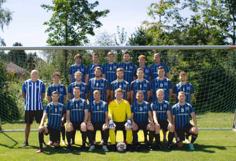 TuS Horn Senioren Fußballmannschaft in blauen Trikots posiert vor einem Tor auf dem Spielfeld.